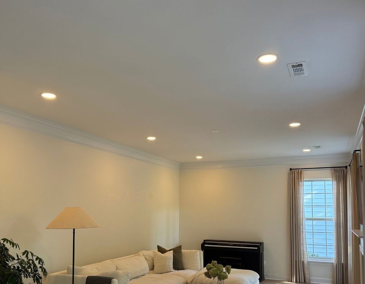 Living room after — warm recessed lights spread evenly across the ceiling