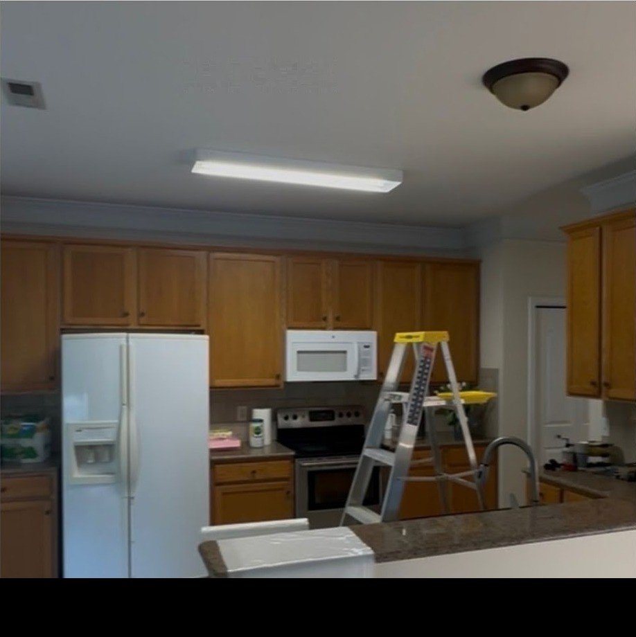 Kitchen before — an old fluorescent box light over oak cabinets