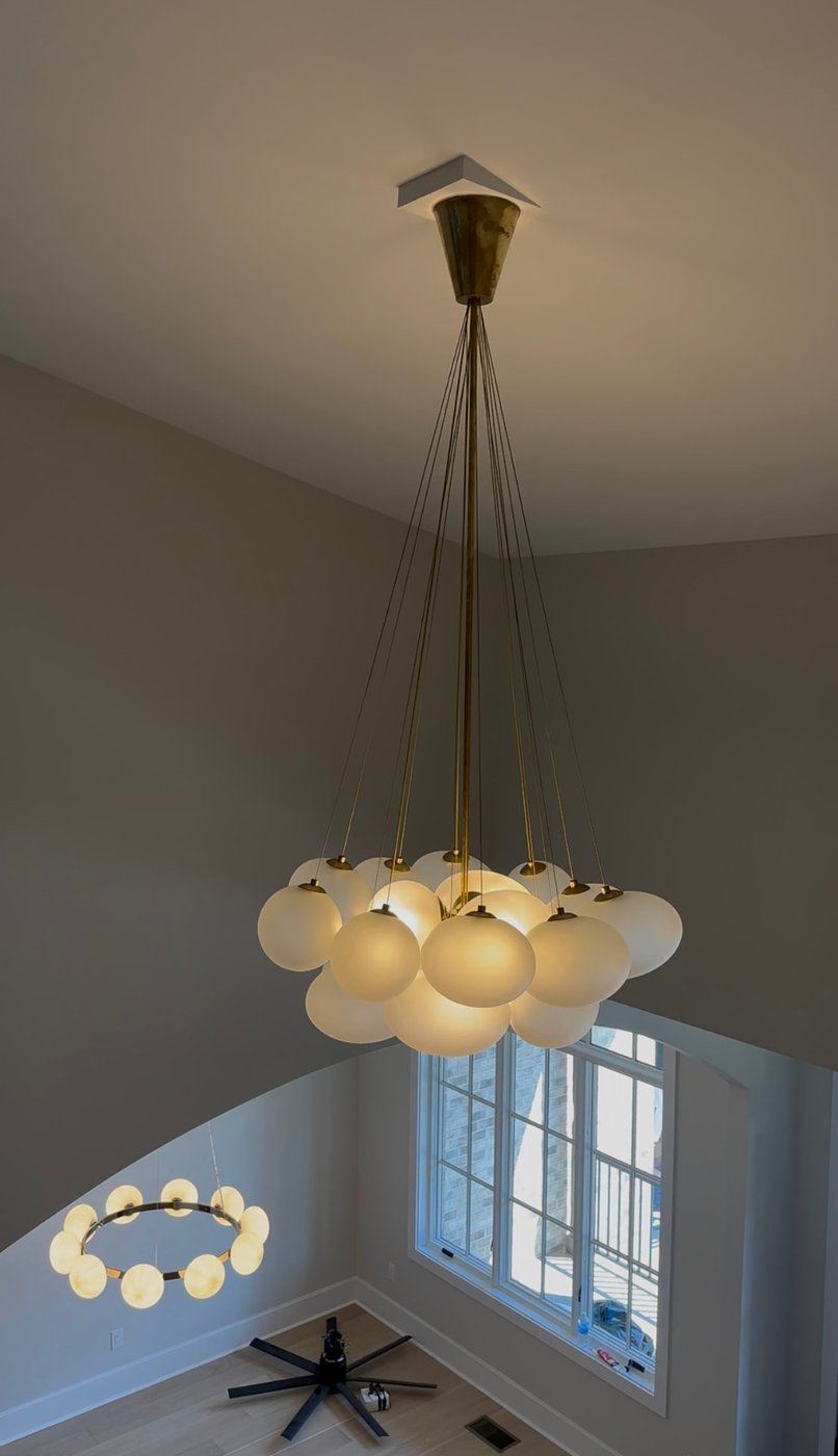 Clustered globe chandelier hanging in a two-story foyer